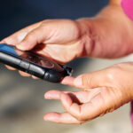 Woman pricking finger to measure blood sugar