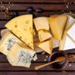 several cheeses on wooden cheese board