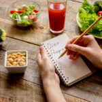 writing down diet plan in a notebook