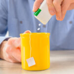 Man putting artificial sweetener in his tea