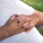 close up of man's hands resting on his stomach