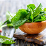 wooden bowl overflowing with fresh spinach