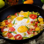 Fried eggs and veggies in cast iron skillet