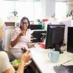 Two women eating healthy snacks at work