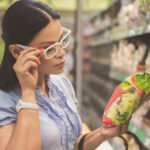 Customer checking ingredient list on bag in grocery store