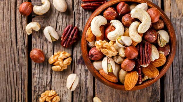 Mixed nuts in bowl on wooden table