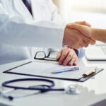 Physician shaking hands with patient